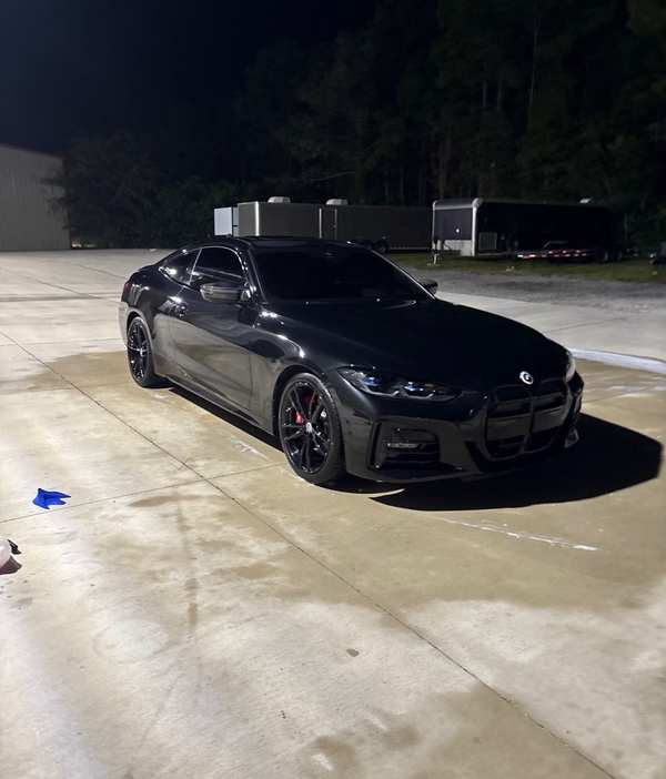 Black BMW 4 Series at dusk after a full detail, paint holding the last of the light