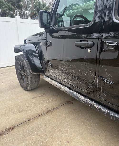 Black Jeep Gladiator before washing — road film and dried water spots dulling the paint
