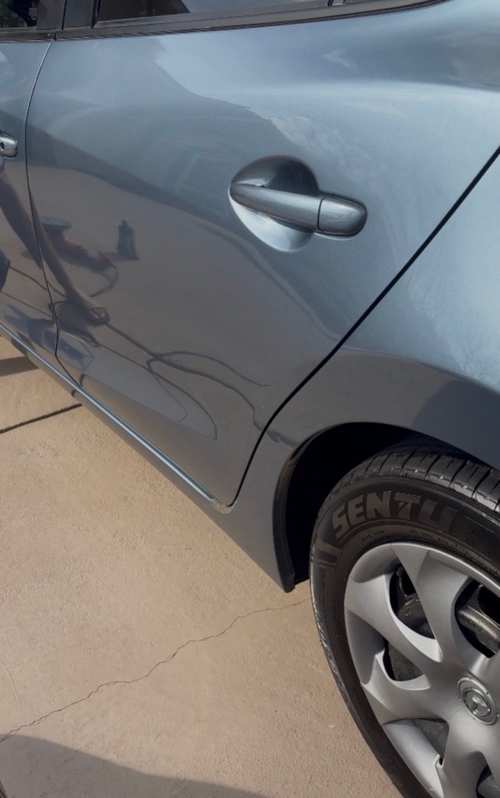 The same Mazda 3 door panel after paint enhancement — swirls polished out, reflection sharp