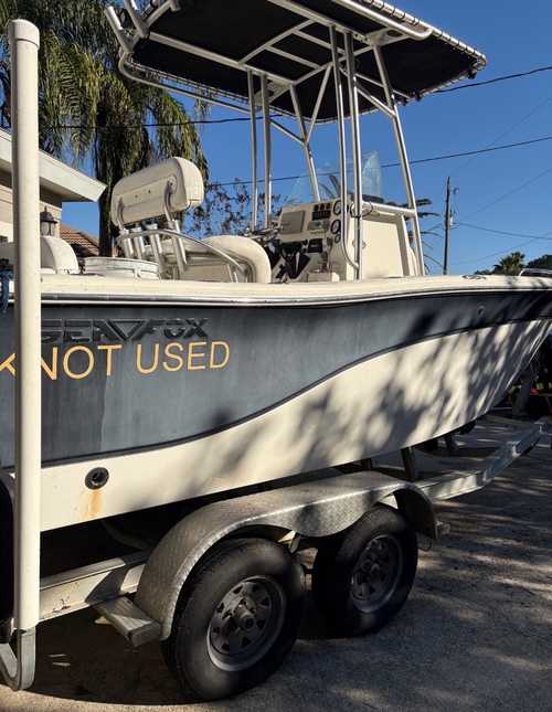 Sea Fox center-console boat on its trailer before detailing — oxidized gel coat and waterline staining