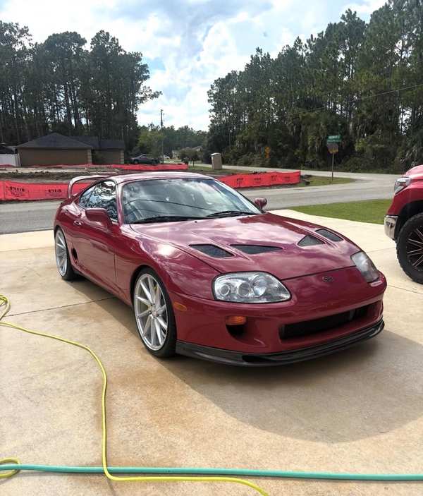 Red Toyota Supra on a Palm Coast driveway, freshly washed and drying