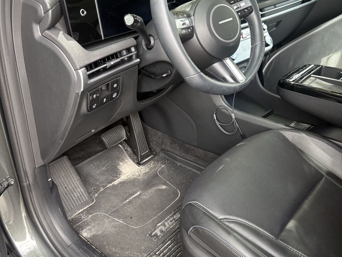 Hyundai Tucson driver footwell before detailing — sand and grit ground into the floor mat